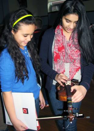 Photo by Nancy Kriz Music mentor Henal Shah tunes North Main fourth-grader Jayla Farinacci&#xed;s violin prior to the start of orchestra rehearsal.
