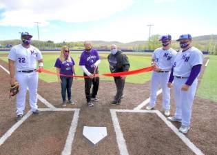 Before the game Athletic Director Lori Hock cuts the ribbon to open the baseball field with School Board President Staci McCleary and School Board of member Anthony Anderson. Photos by William Dimmit.