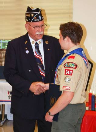 Photo by Scott Berger Jerrold P. Oser Sr., the adjutant of the Mulligan-Eden Post 1573, congratulates William Boese during the young man's &quot;Eagle Scout Court of Honor&icirc; held June 9 at the Monroe Volunteer Ambulance building.