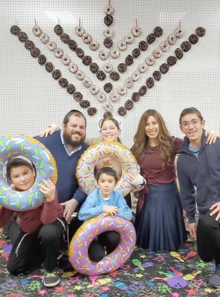 The Burston family, who direct Chabad of Orange County, at last year’s donut Menorah. This year there will be a special effect menorah with sparklers and lasers at the Monroe Menorah Lighting &amp; Festival on December 18.
