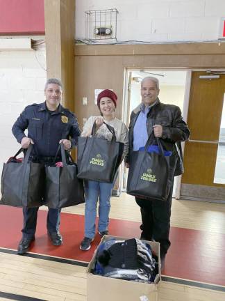 (Left to right)Police Chief Patrick Tenaglia, Kimberly Gutman, and Mayor Lou Medina with bags of hats and gloves they collected for the drive.