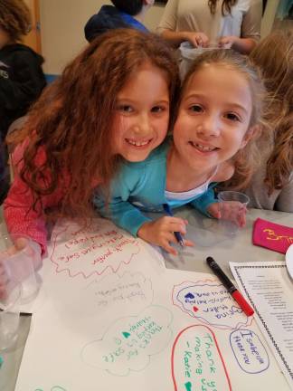 Photos provided Ava Lejovitzky-Reich and Lizzie Deskin, age 8, write a message on a police-car shaped card to be presented to the Monroe Police Department as part of Chabad Hebrew School&#x2019;s Cookies For Cops appreciation event.