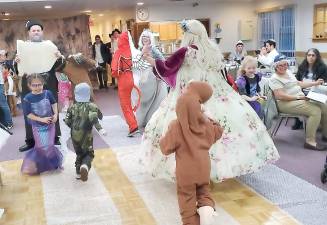 Celebrants drown out the name of Haman, the villain in the Purim story, by jumping on bubble wrap, as Rabbi Pesach reads the Megillah, the Scroll of Esther, at Chabad’s ‘Purim in Israel’ celebration. Photo credit: Taylor Alexis.