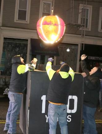 Members of the Warwick Fire Department raise the Warwick Apple.