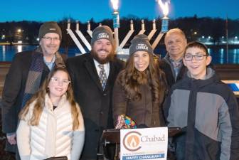 Monroe Village Mayor Neil Dwyer, left, and Monroe Town Supervisor Tony Cardone, second from left, at a Monroe Menorah Lighting in the past. They are pictures with Rabbi Pesach and Chana Burston, along with some of their children. This year’s Menorah Lighting in Monroe will be held on December 18.