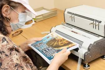 An Orange-Ulster BOCES staff member uses a machine to bind a workbook at the Regional Education Center at Arden Hill in Goshen. Photos by Tom Bushey.