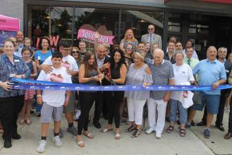 Among those attending the ribbon-cutting were, from left to right: Anthony Scancarello; Sal Scancarello Jr.; Marissa Scancarello (cutting ribbon); Christine Scancarello, (shop owner, cutting ribbon); Barbara Martinez, president, Goshen Chamber of Commerce; Edison Guzman, president, Monroe Chamber of Commerce; Anthony Cardone, Monroe Town Supervisor; Monroe Town Councilmen Michael McGinn and Richard Colon; Monroe Village Trustees Debbie Behringer and Dorey Houle; Monroe Village Mayor Neil Dwyer; and Harriman Mayor Steven Welle.