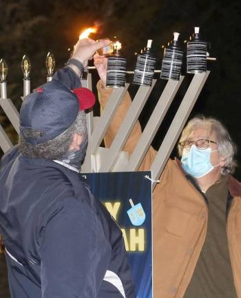 Police Officer Michael Cohn of Warwick and Dr. Ira Kanis of Monroe light a candle at Chabad’s Hanukkah Drive-in Experience in Chester.
