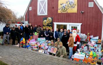 On Dec. 13 state, county and local officials, Warwick Supervisor Michael Sweeton, MSgt. Sara Pastorello, Pete and Laura Rollins, WTBQ Station owner Frank Truatt and Manager Taylor Sterling, representatives of local businesses, veterans organizations and other volunteers pose with Santa and the arranged toys placed outside for pick-up for the sixth annual Toys for Military Tots drive. Photo by Roger Gavan.