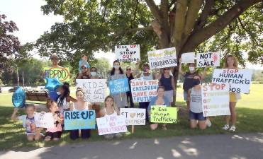 Members of the S.T.O.M.P. movement hold up their signs as they stand at the intersection of 17M and Millpond Parkway on Saturday. Photo by William Dimmit.