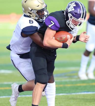 Crusader QB Michael Zrelak (#7) powers his way toward the end zone with a Goldback defender on his back.