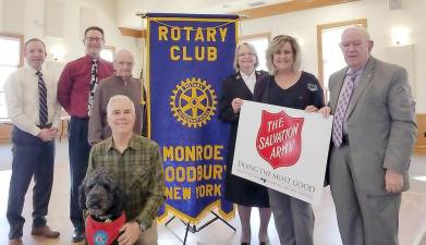 Pictured from left to right are: Eric Hassler, Aldis Ansons, Jay Wilkins, Major Mary Moore of the Salvation Army, Elaine Smith, Charlie Pakula and Cliff Berchtold (kneeling with Rocket). The Monroe-Woodbury Rotary Club raised $8,500 for the Salvation Army this holiday season as part of the Army's bell ringing kettle campaign.