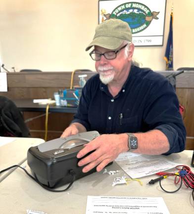 Monroe Repair Cafe volunteer Michael Fradianni fixes a jammed shredder on Dec. 6.