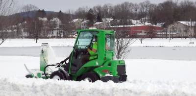 A Village of Monroe DPW crew member clears the sidewalks around the Millponds in Monroe last week after a storm dropped at least a foot of snow on the area. Photo by Sharon Scheer .