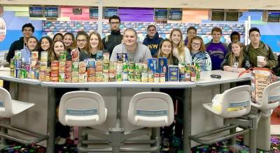 The Monroe-Woodbury girls and boys varsity bowling teams ran a non-perishable food drive to benefit Our Father's Kitchen at Sacred Heart Church in Monroe. The young athletes are pictured here at the Colonial Lanes in Chester with the 72 items they delivered to the food pantry.