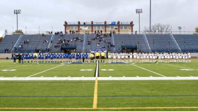 The Vikings in blue and the Crusaders in white line up before the Section 9 Championship game.
