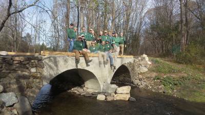 The volunteer crew from the New York New Jersey Trail Conference, pictured last November, enjoys the view from the newly rebuilt bridge over the Seely Brook in Goosepond State Park (Photo by Frances Ruth Harris)