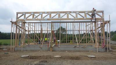 Tom Becker, pictured high up in the emerging structure, volunteered to help raise the Jarvis R. Boone Memorial Amphitheater at Larkin’s Green.