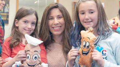 Heather Sentell, 8, of Monroe, and Juliana Loftus, 9, of Goshen, show their “Challah Pillows” to Chana Burston.