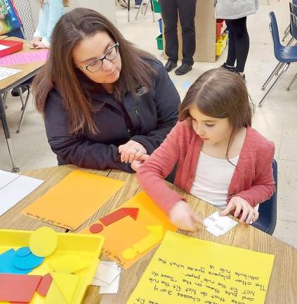 Charleigh Cicchetti shows her mom how to sort shapes using the attribute rule.