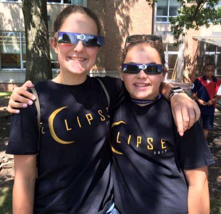 Photo via Facebook Eclipse watchers and Highland Mills residents Jessica Ader, left, and her sister Jordan wear their commemorate eclipse shirts as balance out watching the eclipse and getting ready for volleyball practice.
