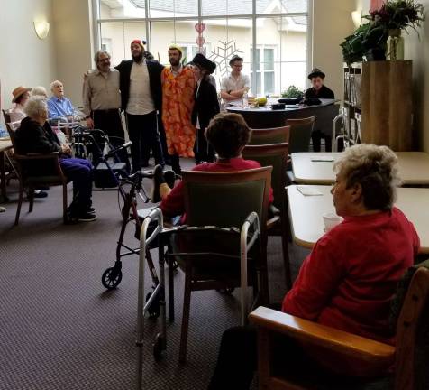 Chabad of Orange County volunteers, led by Rabbi Pesach and Chana Burston, together with Gabai Ira Kanis, spread Purim joy to The Promenade at Tuxedo and Elant in Goshen. Duvy Burston plays the piano.
