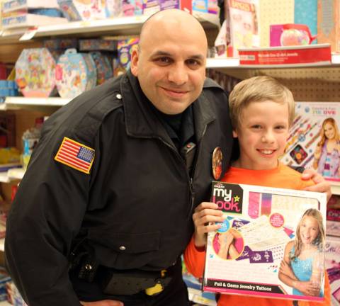 Logan Brown with Police Officer Mike Farahvashi picking out a toy for his sister.