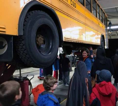 The bus garage hosted a trip organized by the Monroe-Woodbury Parents Advocating Gifted Education (PAGE) so kids could learn more about what it takes to keep a bus safely on the road. These visitors had a chance to see what the underneath of a bus looks like as mechanics explained the details of the work they do.