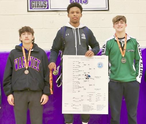 Jordan Brown stands on top of the podium after finishing in first place at 138 pounds.