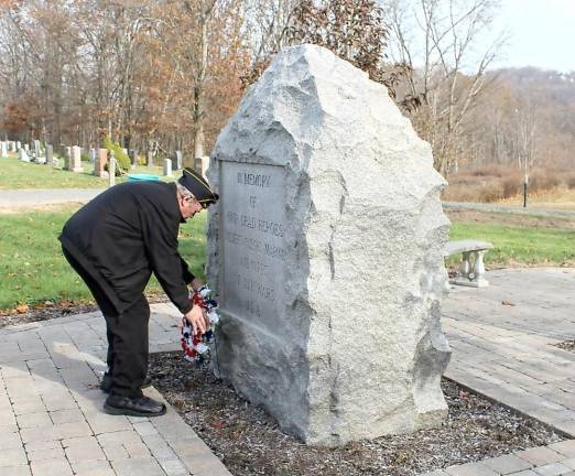 Veteran Ken Smith places the ceremonial wreath at the base of the Heroes’ Memorial at the conclusion of the Veterans Day Ceremony