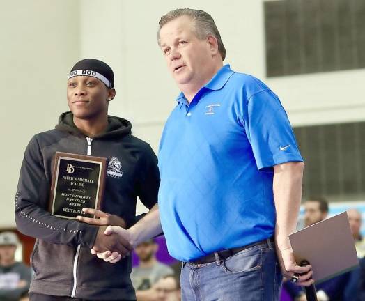 Marcus Charlot receives the Patrick Michael D’Aliso “Most Improved Wrestler Award” from Tom Kennedy before his final match.