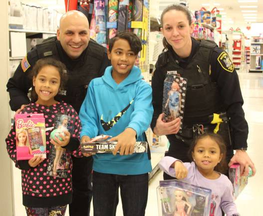 Photos by Linda Mastrogiacomo Woodbury Police Officers Michael Farahvashi, left, and Kristen Potter shopping with Olivia, Andrel and Aubrianna Merriweather.