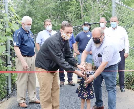 Orange County Executive Steven M. Neuhaus cuts a ceremonial ribbon to celebrate the completion of the trailhead access to the Heritage Trail in Harriman with Harriman Mayor Stephen H. Welle and Welle’s granddaughter, Isabella Bruno, 2. Photo provided by Orange County.