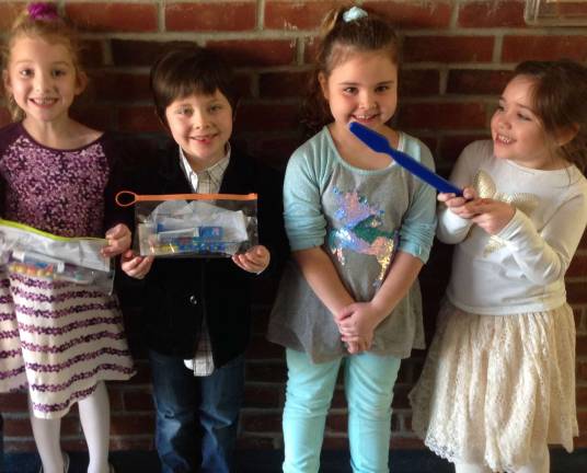 Photos provided Kindergarteners Sophie Baer, left, Thatcher Givens, Antonina Chillino and Carmen Golden, who is pretty handy with this oversized toothbrush.