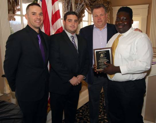 Benedict Brafi, right, receives the Tom Kennedy Monroe-Woodbury Parents Football Club Scholarship. Also pictured are Coach Ryan Baldock, Coach Jordan Bari and Tom Kennedy.