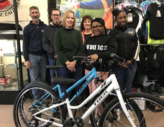 Rich Cruet, left, owner of The Bicycle Doctor; Don Karlewicz, club treasurer; Carol Kalajian, club volunteer; Pastor Rosey Andrews of Northeast Gateway to Freedom; with bicycle recipients Yazzari Reynolds and Tionna Lawrence and the bikes presented to Northeast Gateway to Freedom.