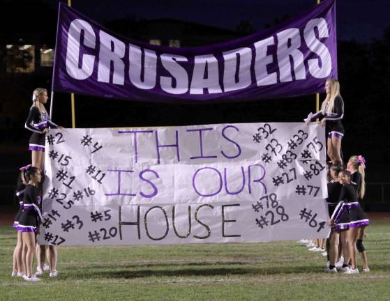 Photos by William Dimmit The Crusader Cheerleaders hold up the banner honoring the seniors on the football team.
