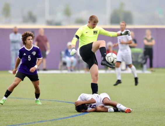 Crusader goalie Parker Giles clears the ball away from the front of his net over a Wildcat player. Photos by William Dimmit.