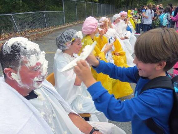 Third-grader Justin Huck offers some friendly revenge on gym teacher Joseph Pesce for all those sit-ups in gym class with his whipped cream pie.
