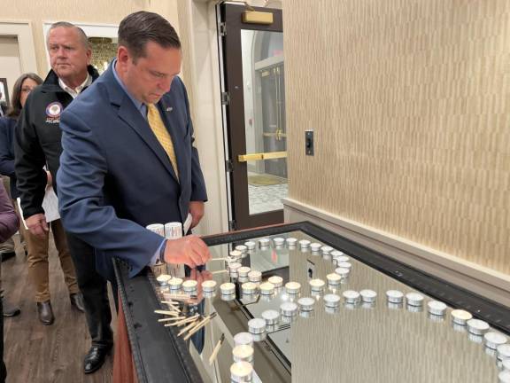 Orange County Executive Steve Neuhaus lights a candle.