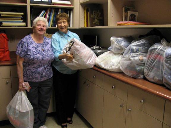 Carol Morgan and Sr. Carmel Therese Favazzo at Queen of Apostles Center with some of the food and clothing donations for My Father&#xed;s Kitchen in Monroe.