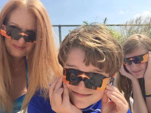 Photo via Facebook Monroe resident Cristina Brueck Kiesel and children Ryan and Jessica made sure they had their eclipse glasses with them during their Point Pleasant, N.J., vacation.