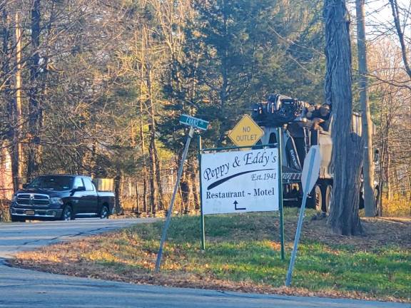 A logging truck approaches with another delivery.