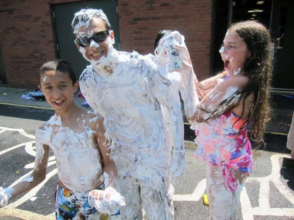 Camper Riley Crowe, 11, of Salisbury Mills, right, and Chaim Pincus, 12, of Chester, left, have fun on Wacky Water Day at Camp Gan Israel as they cover counselor Lee Stanton of Greenwood Lake with shaving cream.