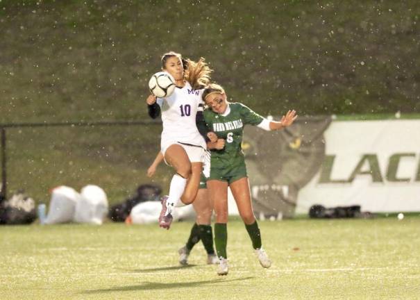 Ella Natal ,#10, battles a Patriot player in the rain for a loose ball.
