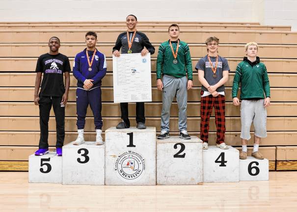 Elijah Brown stands on the podium after finishing in first at 138-lb. class.