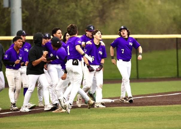The Crusaders mob Joey Bauer #26 after he won the game with a single in the seventh.