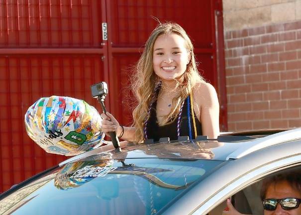 Senior Cat Schiff enjoys her last trip through the High School parking lot.