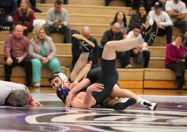 Photos by William Dimmit Crusader Carter Stewart (160 lbs.) pins his Wildcat opponent in 46 seconds.