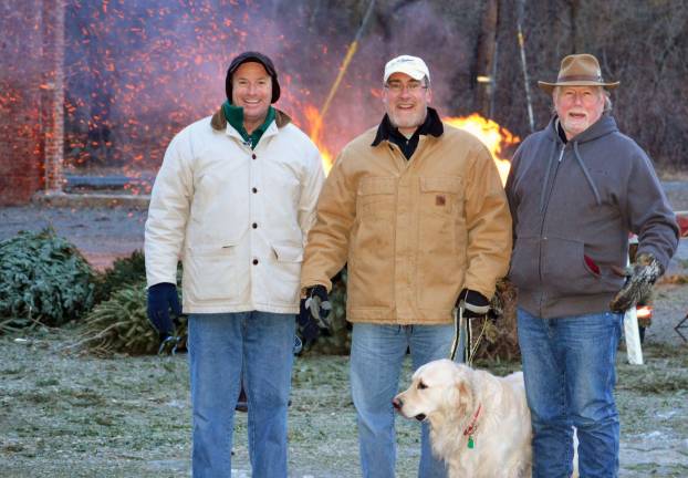Tuxedo Town Supervisor Peter Dolan and Councilman Cliff Loncar and Gary Phelps take a break from loading recycled Christmas trees into the bonfire last Saturday.